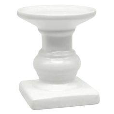 a white vase sitting on top of a table