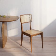 a wooden chair sitting next to a table on top of a hard wood floor