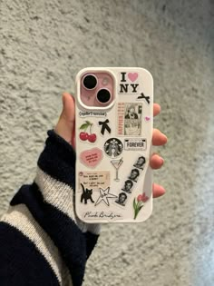 someone holding up their phone case with stickers on it