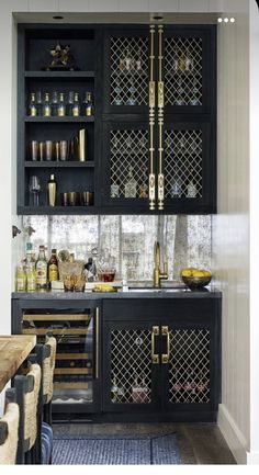 a kitchen with black cabinets and gold trim on the doors, glass shelves in the back