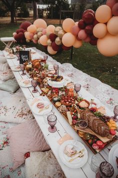 a long table is set with food and balloons