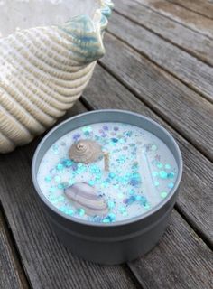 a sea urn sitting on top of a wooden table next to a seashell