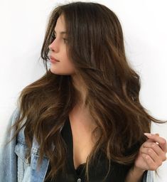 a woman with long hair wearing a jean jacket