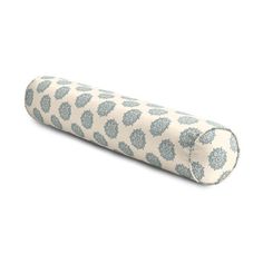 a rolled up pillow on top of a white surface with blue and gray designs in the middle