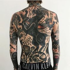 the back of a man with tattoos on his body