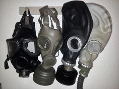 five different types of gas masks hanging on a wall