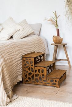 three wooden steps in front of a bed