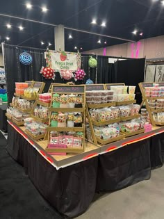 an assortment of food on display at a convention or showroom event with black tablecloths and lights