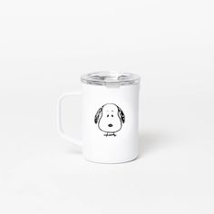 a white coffee mug with a black and white dog drawn on the inside of it