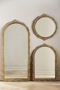 two mirrors sitting next to each other on top of a wooden floor in front of a wall