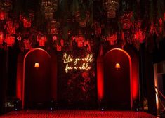 the entrance to an event with red lights and chandeliers