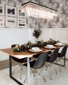 a dining room table is set with plates and candles