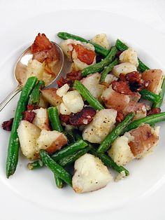 a white plate topped with green beans and potatoes