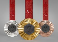 three medals are shown in front of two red and one silver ribbons, with the words pure joy on them