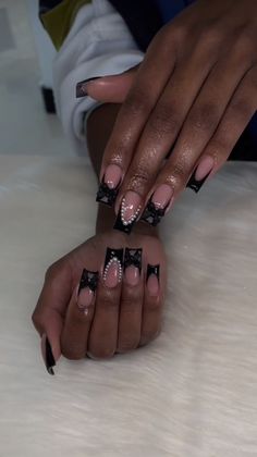 two hands with black and white nail designs on them