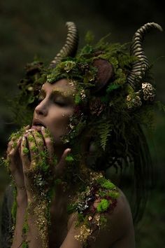 a woman is covered in moss and plants