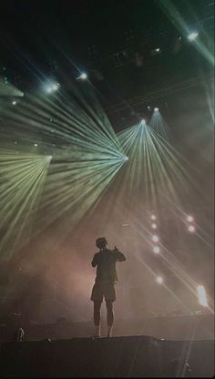 a man standing on top of a stage with lots of lights in front of him