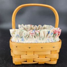 a wooden basket with fabric in it on a table