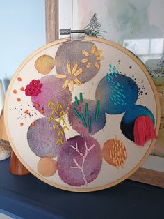 an embroidery project is being displayed on a shelf