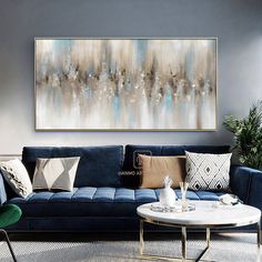 a living room with blue couches and paintings on the wall above them, as well as a coffee table