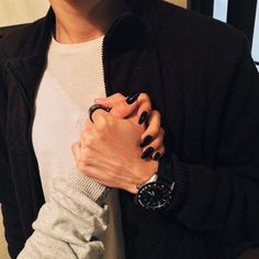 a person with black nails and a watch on their wrist