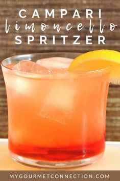 the campari lemoncello spritzer in a glass with an orange slice