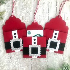 three red christmas gift bags hanging from strings