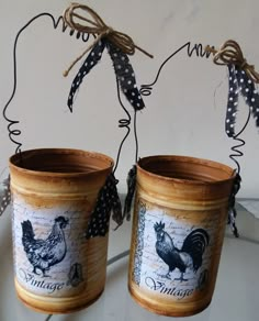 two pots with roosters on them sitting on a table