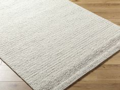 a white rug on top of a wooden floor