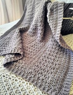 a crocheted blanket sitting on top of a bed