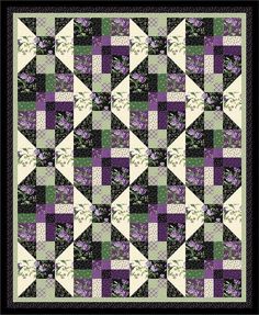 a purple and green quilt with white flowers on the front, along with black border