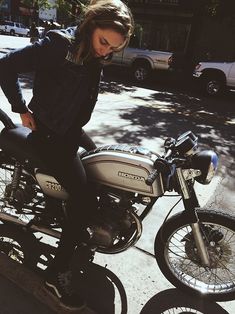 a woman sitting on top of a motorcycle