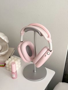 a pair of pink headphones sitting on top of a table next to a candle