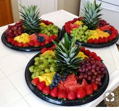 three plates filled with fruit on top of a white kitchen counter next to a refrigerator