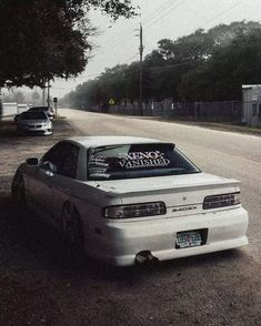 a white car parked on the side of a road