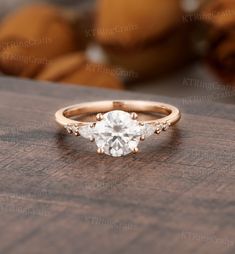 an engagement ring with three stones in the center on top of a wooden table next to bananas