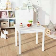 a small white table with stuffed animals on it in a child's playroom