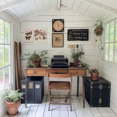 an old fashioned desk with a typewriter and some potted plants next to it