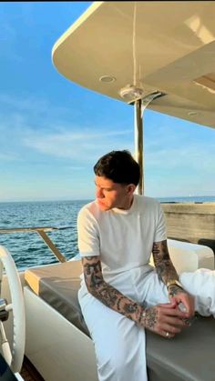 a man with tattoos sitting on a boat