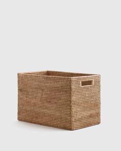 a large woven basket with handles on the bottom and sides, sitting against a white background