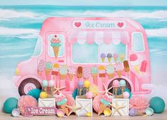 an ice cream truck is parked on the beach with candy and other items around it