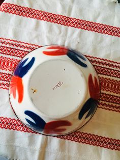 an empty bowl sitting on top of a red and white table cloth