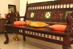 a wooden bench with pillows on it in the middle of a room next to other furniture