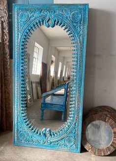 a mirror sitting on top of a floor next to a blue bench