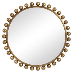 a round mirror with gold balls on the rim and an oval mirror frame in the middle