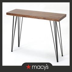 a wooden table with black hairpinks on it and the words macy's above it