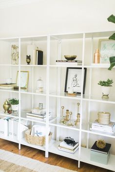 a white book shelf filled with books on top of a wooden floor