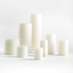 several white candles are arranged in the shape of cubes on a white background,