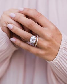 a woman's hand with a diamond ring on her finger