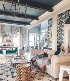 a man laying on top of a couch in a living room next to a table